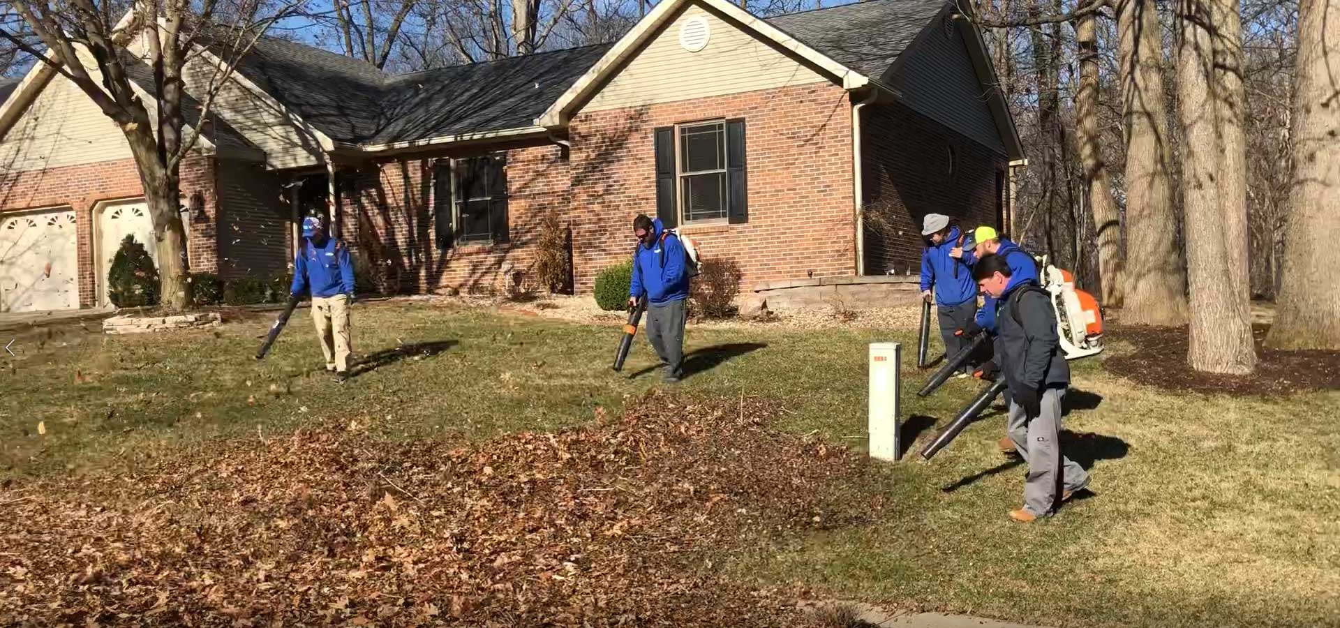 Maintenance workers clearing leaves with leaf blowers in Alton, IL.