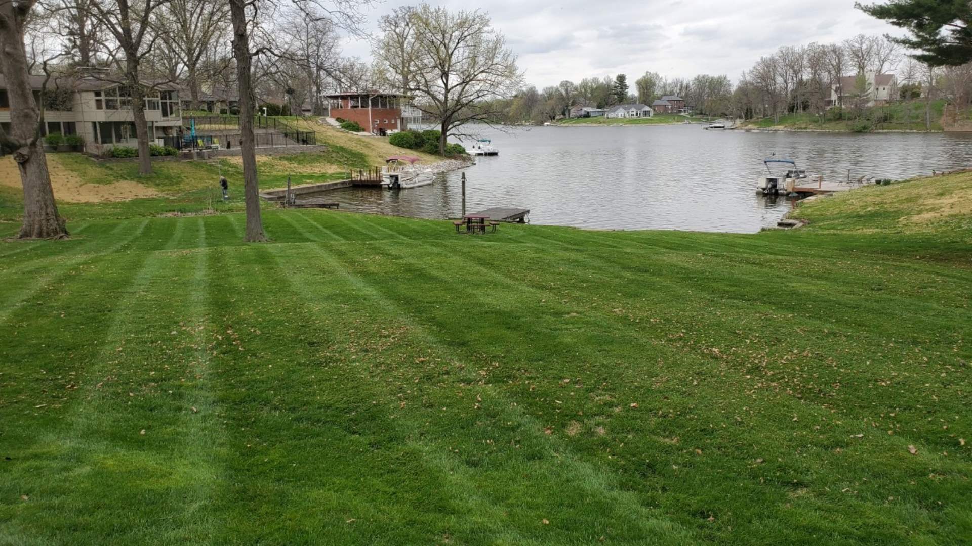 Mowed lawn beside lake home front in Brighton, IL.