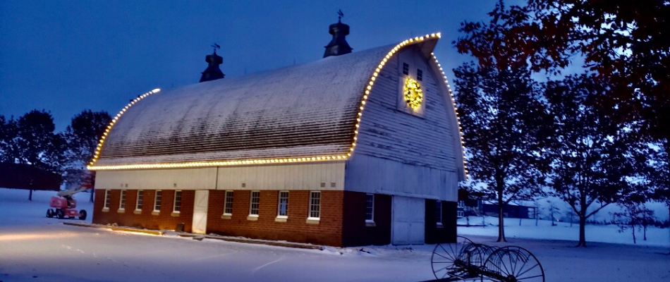 Holiday lights installed around cylinder shaped roof of a building in Roxana, IL.